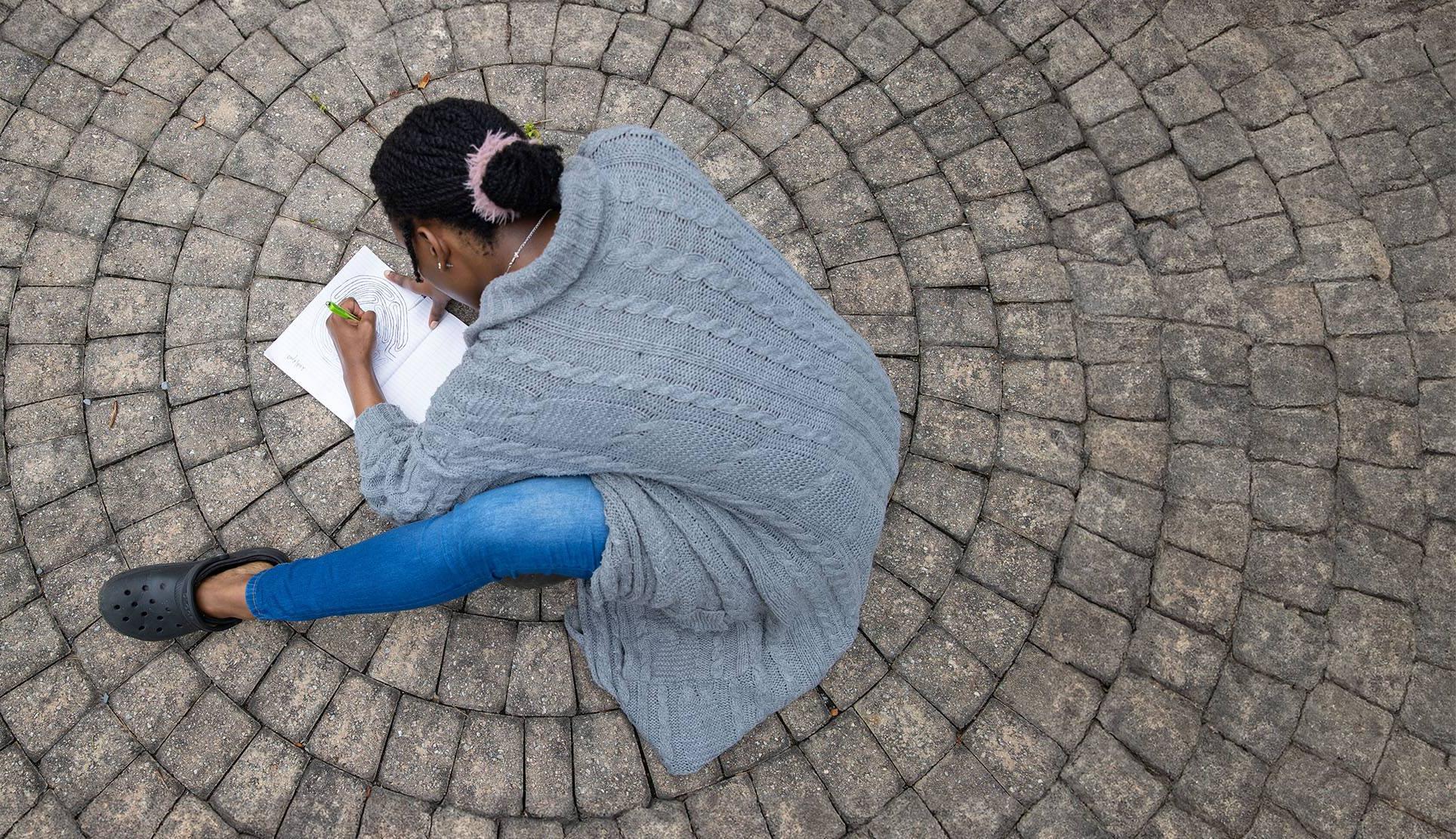 student drawing a brain on circular pavement